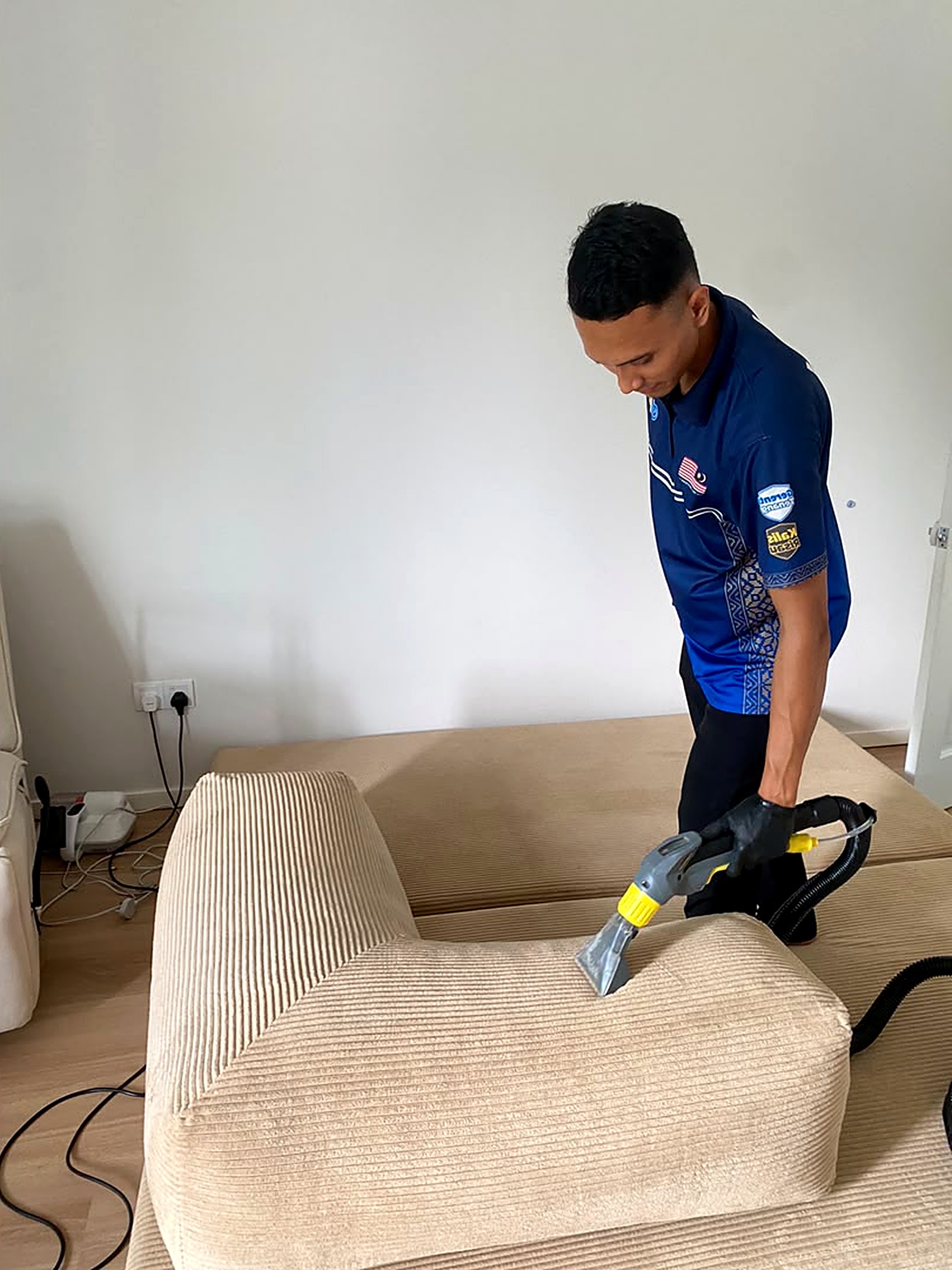 AMD CLEAN technician cleaning a fabric sofa
